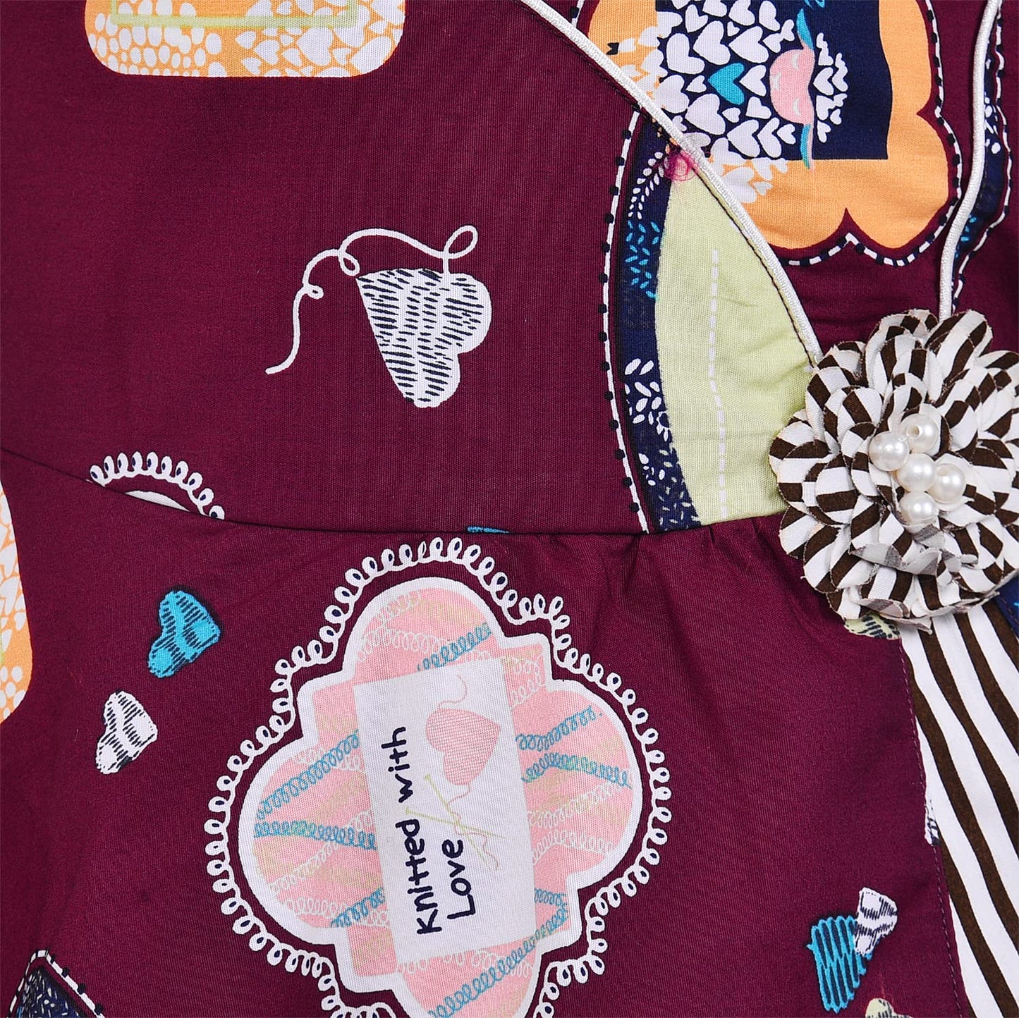 Girls Maroon Printed Cotton Dress with Asymmetrical Panel & Floral Accent